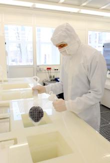 Employee rinses wafers in chemical bench